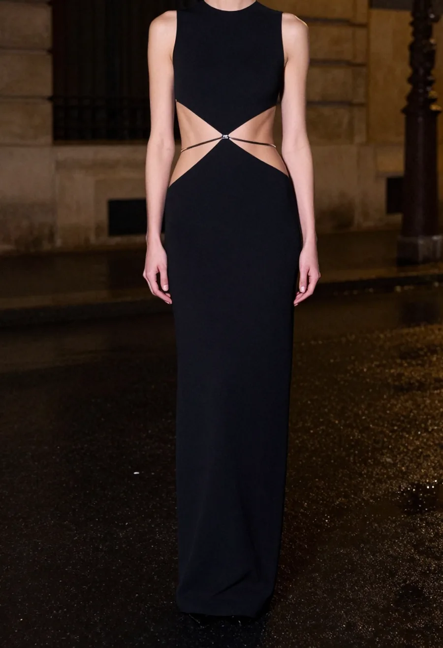 Catalogue-style front view of a model wearing the Vertèbre Gown, fully open back with chrome spine straps, evenly lit.