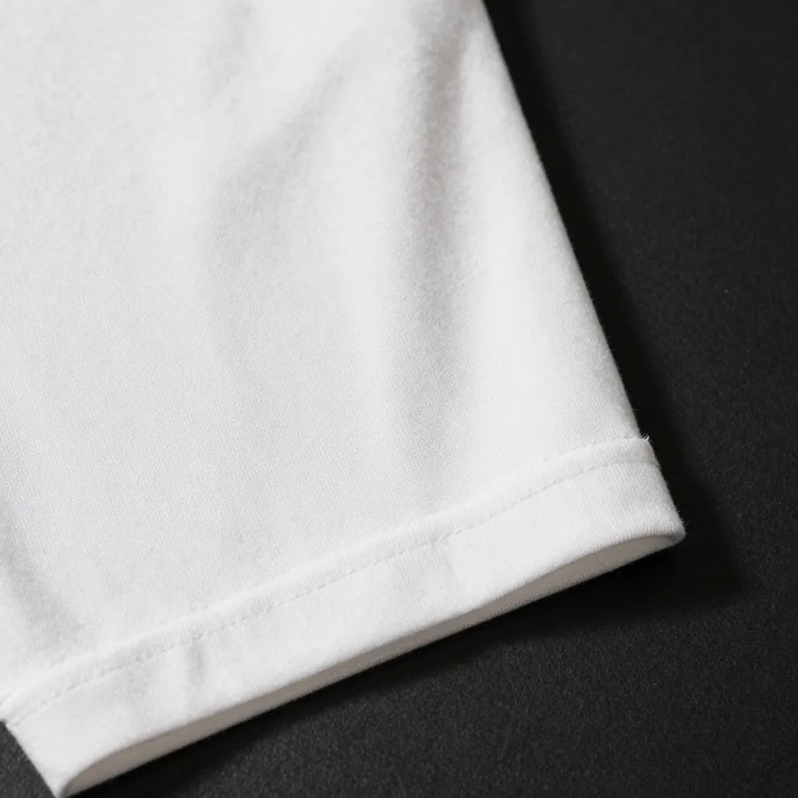 Close macro detail of the material and construction of a white heavyweight cotton t-shirt with an oversized gold P emblem across the back.