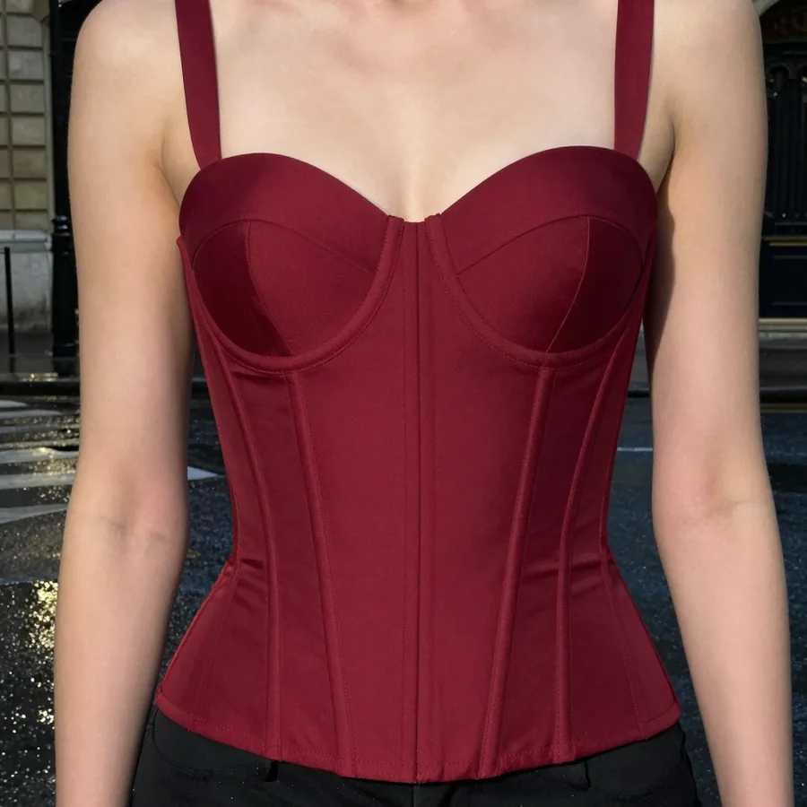 Close detail crop of the exposed boning and sweetheart neckline of the Oxblood Corset Top, no face visible.
